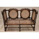 A Carolean style oak and rattan settle, early 20th century, each of the four oval rattan panels with