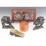 A pair of Chinese hardwood models of water buffalo and riders, each 18cm high, with an oriental