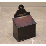 An early 19th century mahogany salt box, the shaped back with integrated ring aperture, over the