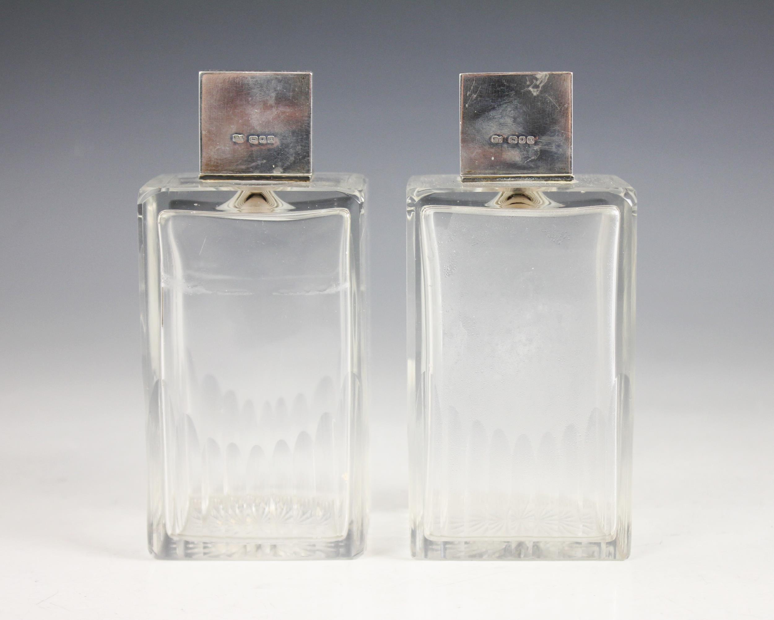 A pair of Art Deco cut glass silver mounted scent bottles, each colourless glass body of rectangular