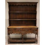 A George III style oak dresser, late 20th century, the moulded cornice above a scalloped frieze