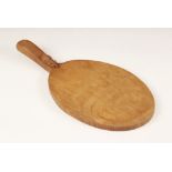Workshop of Robert "Mouseman" Thompson of Kilburn, a carved oak cheese board, of oval form, the