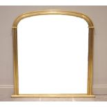 A 19th century style gilt wood overmantel mirror, late 20th century, the arched mirrored plate