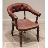 A Victorian mahogany and ox blood red leather club or library chair, the button back backrest raised