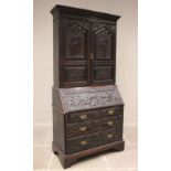 A 19th century carved oak bureau bookcase, the moulded cornice above a pair of cupboard doors