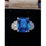 An Art Deco sapphire and diamond ring, the central rectangular emerald cut cornflower blue