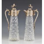 A pair of cut glass silver plated decanters, each of tapering cylindrical form with star cut