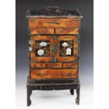 A Japanese black lacquer kodansu cabinet, early 20th century, the desk top cabinet with a hinged top