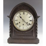 An early 20th century German oak cased mantel clock, the lancet shaped case with barley twist