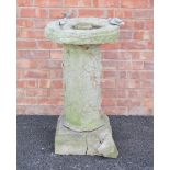 A reconstituted stone bird bath, the circular bath on a cylindrical pillar and square plinth base,