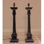 A pair of painted wooden column candlesticks, each of tapering cylindrical form, upon an