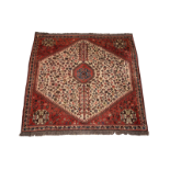 A hand-woven Caucasian carpet in red and ivory colour ways, the central hexagonal field with foliate