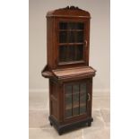 An early 20th century glazed oak freestanding clerks cabinet, the shaped pediment above a glazed