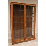 An early 20th century oak and leaded glass display cabinet, the twin doors opening to three later