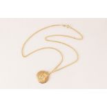 A 9ct gold St. Christopher pendant, of circular form, 22mm diameter, upon a 9ct gold curb link chain
