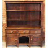 An 18th century and later oak dresser, the later enclosed plate rack with a moulded cornice above