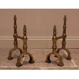 A pair of Arts and Crafts brass fire dogs, each with a pair of ring turned tapering finials upon