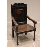 An 18th century and later oak Wainscot chair, the scrolled top rail above a panelled back rest and