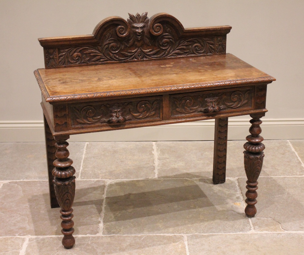 A Victorian carved oak side table, the galleried back centred with a Green Man mask enclosed by