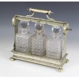 An early 20th century locking tantalus and three fitted cut glass decanters, the rectangular base
