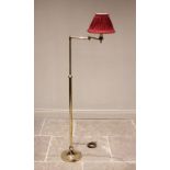 A brass freestanding adjustable reading lamp, 20th century, the articulated arm raised