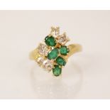 An emerald and diamond 18ct gold cluster ring, the central tiered cluster comprising five oval cut