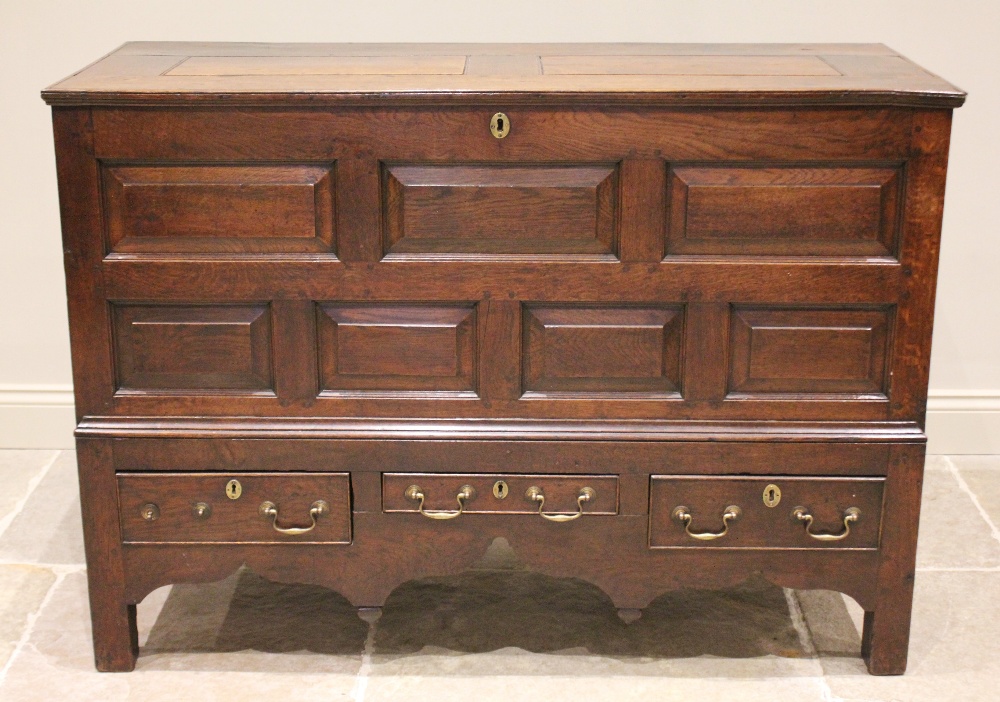A mid 18th century oak mule chest, the hinged removable cover above an arrangement of five chamfered
