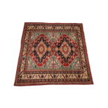 A Caucasian hand knotted village rug, in red, white, blue and green colourways, of geometric design,