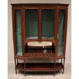 An Edwardian mahogany display cabinet, of canted form, the frieze inlaid with roundel detail above a
