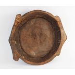 A hand carved elm bowl, 19th century, of shallow circular flat bottomed form with integrated twin