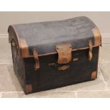 An early 20th century domed canvas motoring trunk, applied with tan leather trim and side handles,