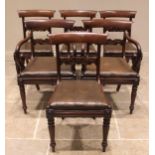 A set of six mid 19th century mahogany dining chairs, each with a concave top rail over a carved