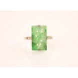 An Art Deco jade and diamond ring, the central rectangular carved and pierced jade panel measuring