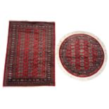 Two Bokhara type rugs, each with multiple octagonal gulls against a vibrant red ground,