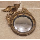 A Regency giltwood and gesso convex wall mirror, of diminutive proportions, the eagle crest