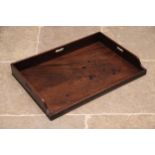 A George III mahogany butlers tray, lacking stand, the three quarter gallery with three hand