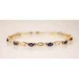 A sapphire and diamond 14ct gold line bracelet, designed as eleven oval mixed cut sapphires, each