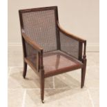 A Regency style mahogany bergere library chair, with cane work back, side and seat panels, raised