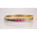 A 14ct gold ‘rainbow’ multi-gem bangle, the central channel set with two rows of princess cut