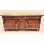 A Victorian mahogany kitchen dresser base, with a rectangular slab top over three cushion frieze