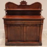 A Victorian mahogany chiffonier, the shaped raised back with a leafy crest over a single shelf