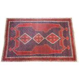 A red and blue ground Persian Aishar rug, with traditional medallion design, the three lozenge