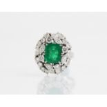 An emerald and diamond ring, the central rectangular step cut emerald measuring 9.7mm x 8.0mm, set