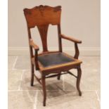 An American type walnut elbow chair, early 20th century, the rail back with incised foliate detail