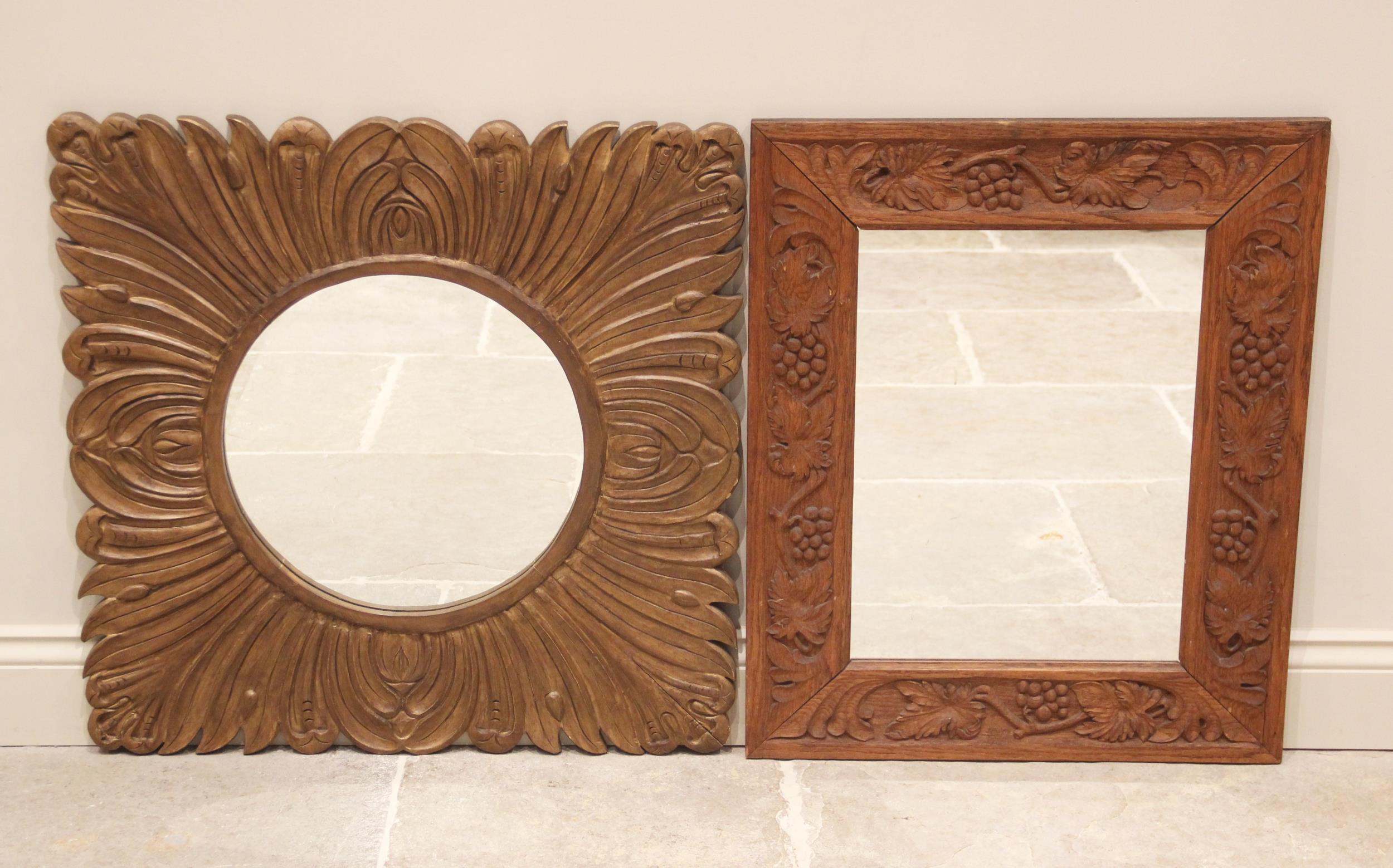 A carved oak wall mirror, 20th century, the rectangular frame carved with grapes and vinery