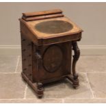 A Victorian figured walnut davenport, the hinged stationery compartment above an oval inset