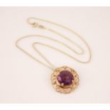 An Egyptian synthetic sapphire set gold pendant brooch, the circular mixed cut synthetic sapphire
