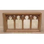 A rustic pine framed Gothic wall mirror, the rectangular mirrored plate overlaid with four Gothic