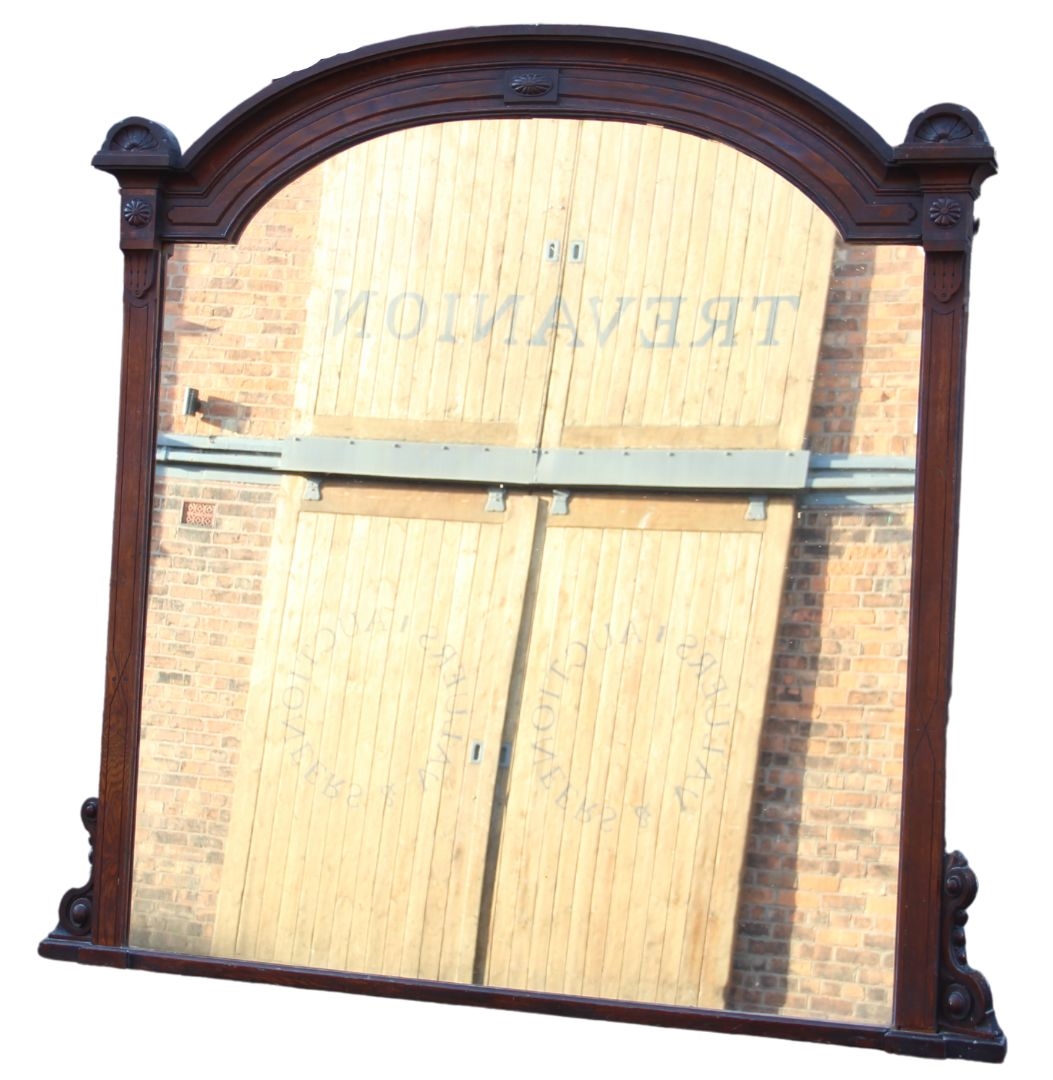 A large Victorian walnut framed over mantel mirror, of break arch form, with lunette moulded finials