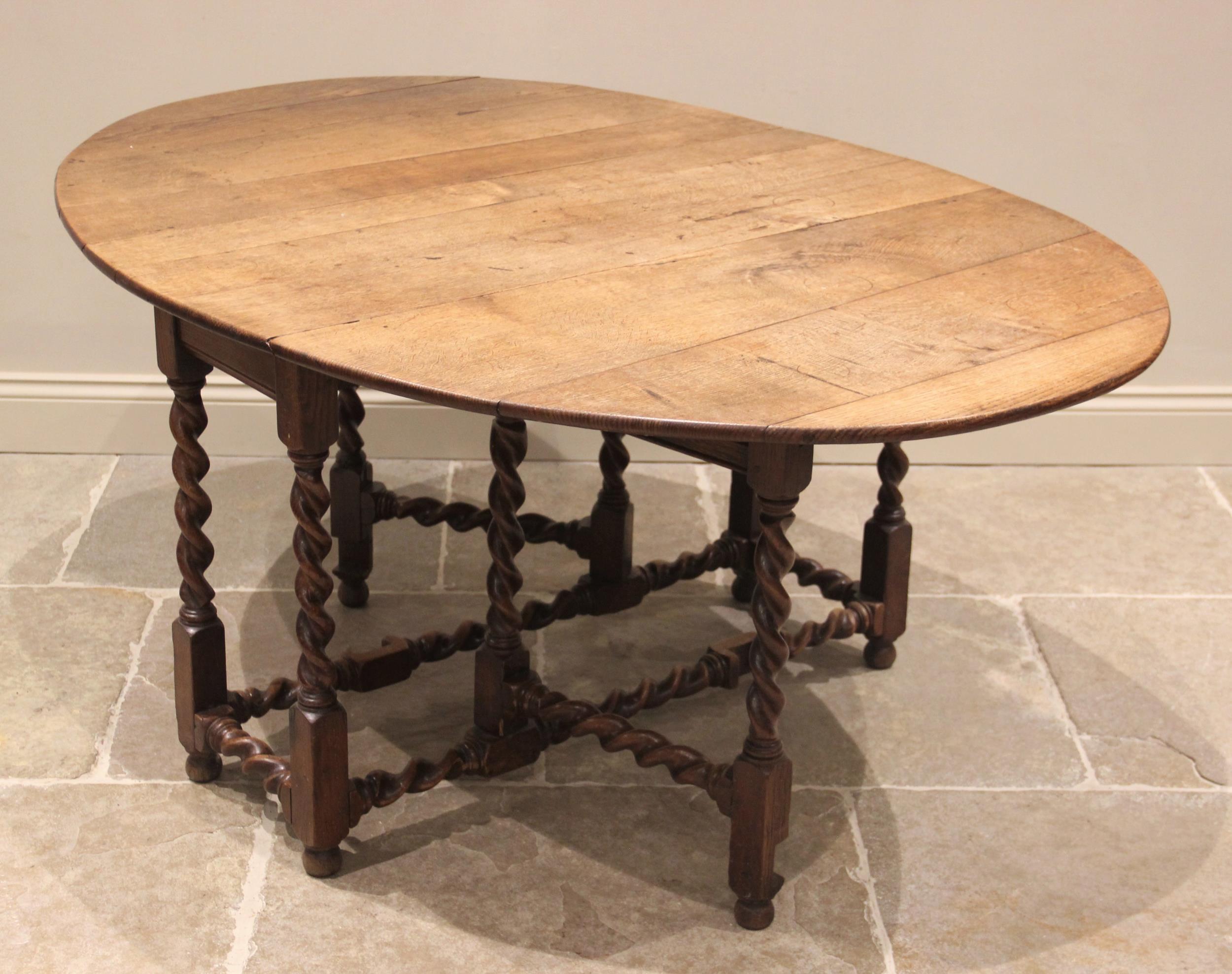 A 19th century honey oak drop leaf dining table, the oval top raised upon barley twist and block - Image 2 of 2